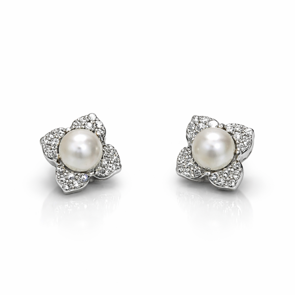 Pair of pearl earrings with silver floral designs on a white background