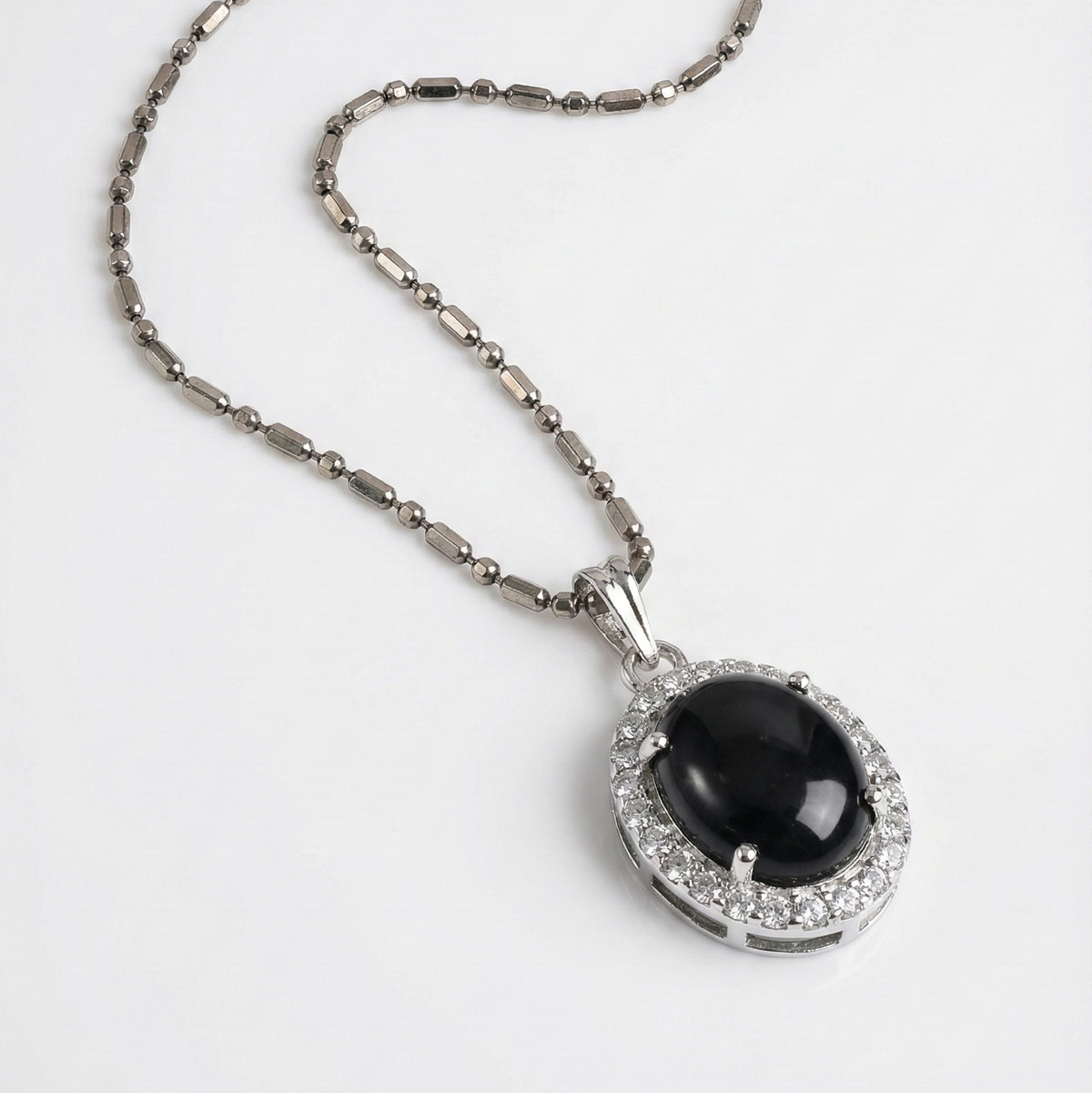 Necklace with a black gemstone pendant on a white background
