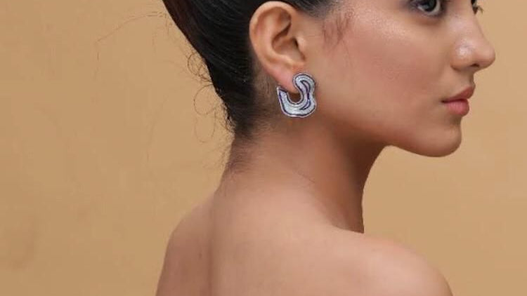 Woman with a stylish hairdo against a beige background