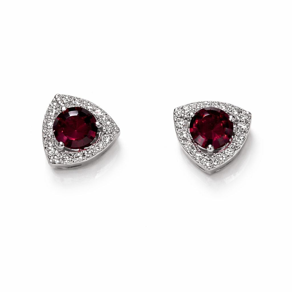 Pair of earrings with red gemstones and diamond like accents on a white background