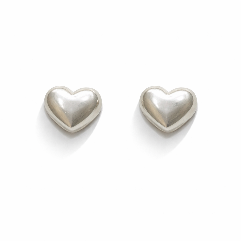 Heart shaped silver earrings on a white background