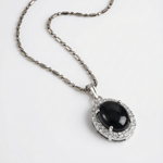 Load image into Gallery viewer, Necklace with a black gemstone pendant on a white background
